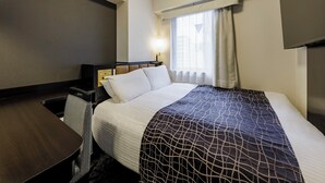 Habitación de hotel con cama, escritorio, silla, televisor y ventana con cortinas.