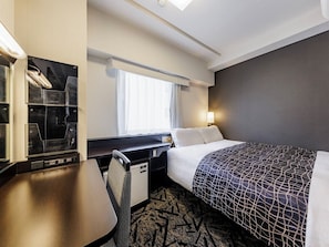 A hotel room with a bed, desk, chair, and a small kitchenette. - APA Hotel Hakata Ekimae 4 chome (Fukuoka)