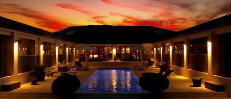 Una piscina al aire libre, sombrillas, tumbonas