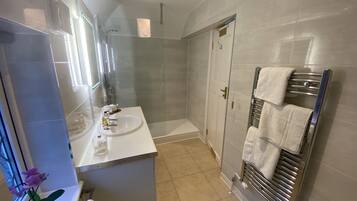 Une salle de bain moderne avec une douche à parois de verre, un meuble-lavabo et un porte-serviettes.