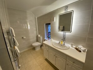 A modern bathroom with a toilet, sink, and mirror.