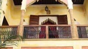 A building with a traditional architectural style, featuring arched windows and balconies. - Riad Marlinea (Salé)
