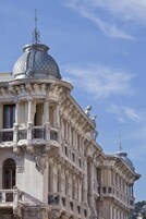 Un edificio storico con dettagli architettonici elaborati, tra cui colonne, balconi e statue.