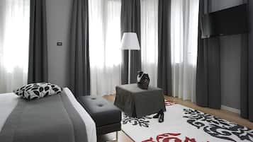 Et moderne hotelværelse med en stor seng, et lille bord, en lampe og et fjernsyn.