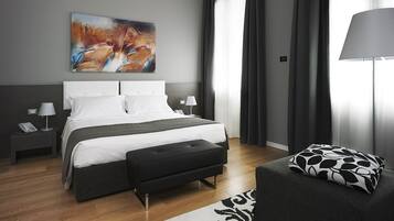 Una habitación de hotel moderna con una cama grande, mesitas de noche, un escritorio y una silla.