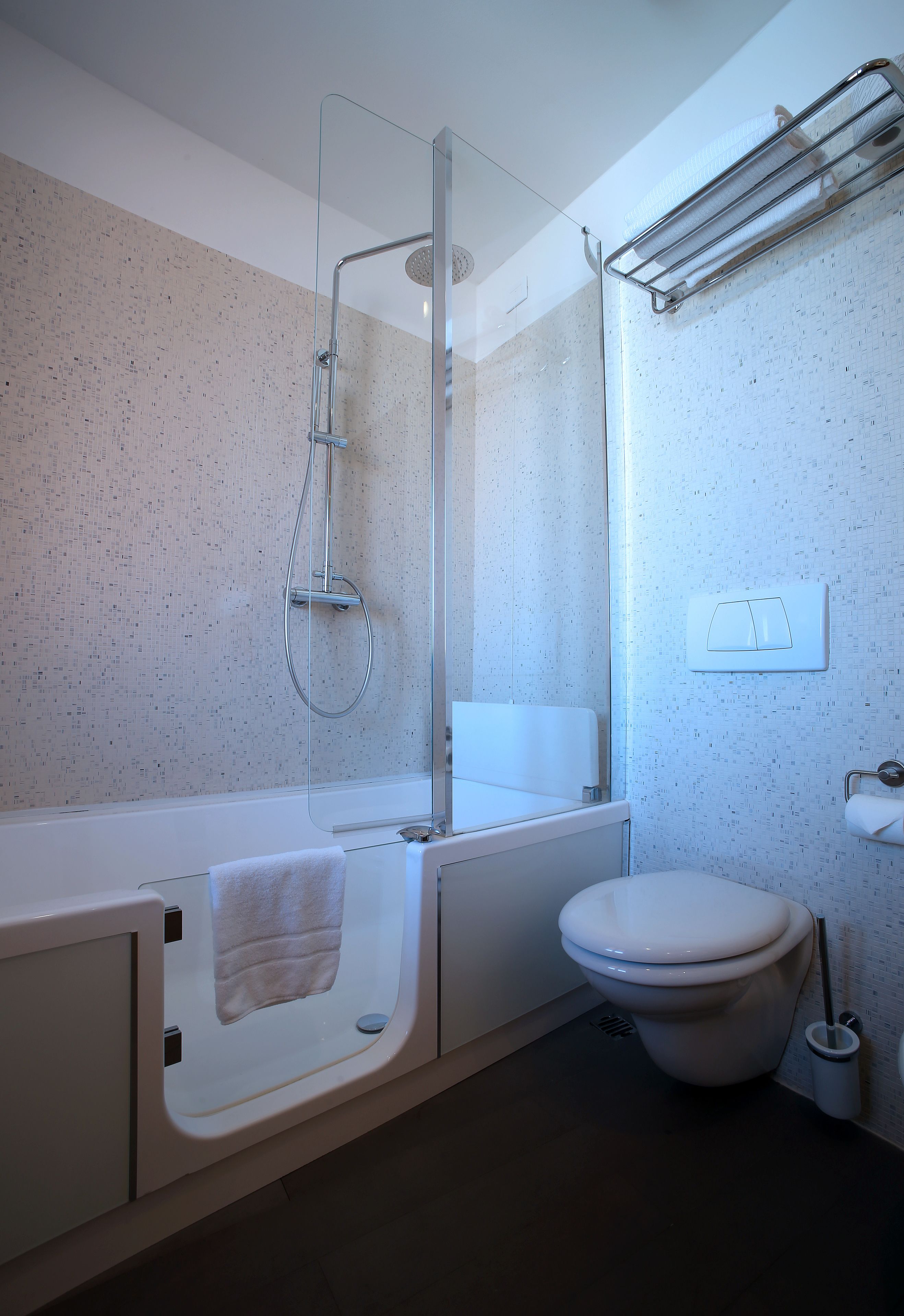 A modern bathroom with a bathtub, toilet, and shower.