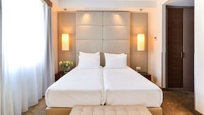 A double bed with a tufted headboard, two bedside tables, and a large window with curtains. - Belgrade Art Hotel, a member of Radisson Individuals (Belgrade)