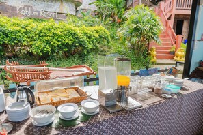 Disposición de bufé con diferentes alimentos y una máquina de café en un resort.