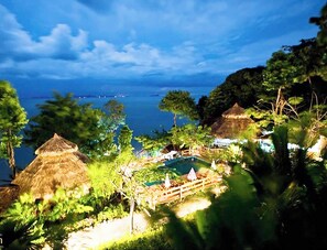 A tropical resort with thatched-roof huts, a swimming pool, and lush greenery. - Koh Jum Resort (Nuea Khlong)