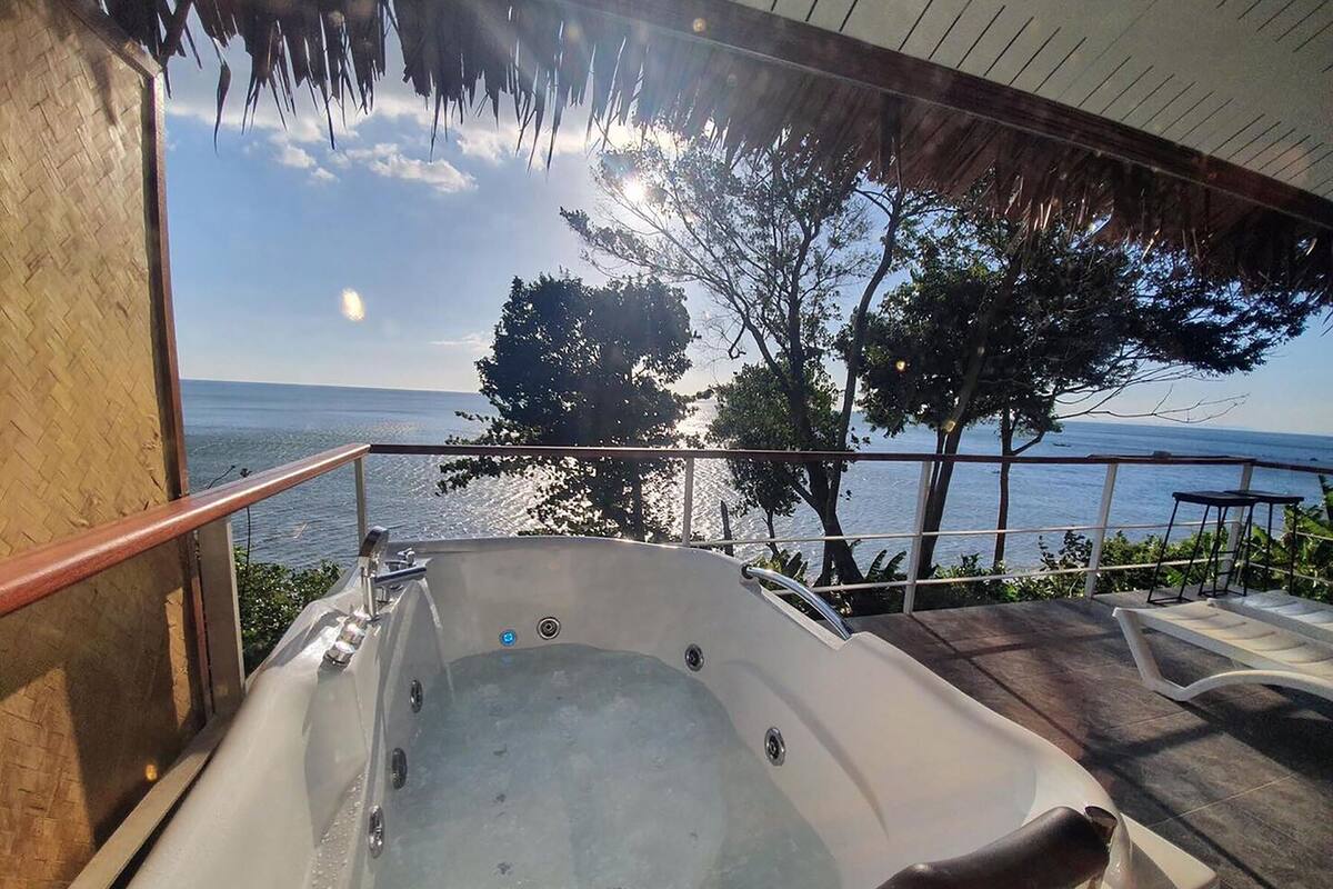 Un jacuzzi con vistas al mar y a los árboles.