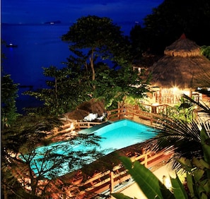 Una piscina al aire libre, sombrillas, tumbonas