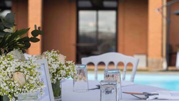 A table set for dining with a pool in the background.