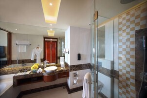 A modern bathroom with a glass shower enclosure, a marble countertop, and a large mirror.