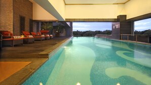 Una piscina con sillas de descanso y vista al cielo.
