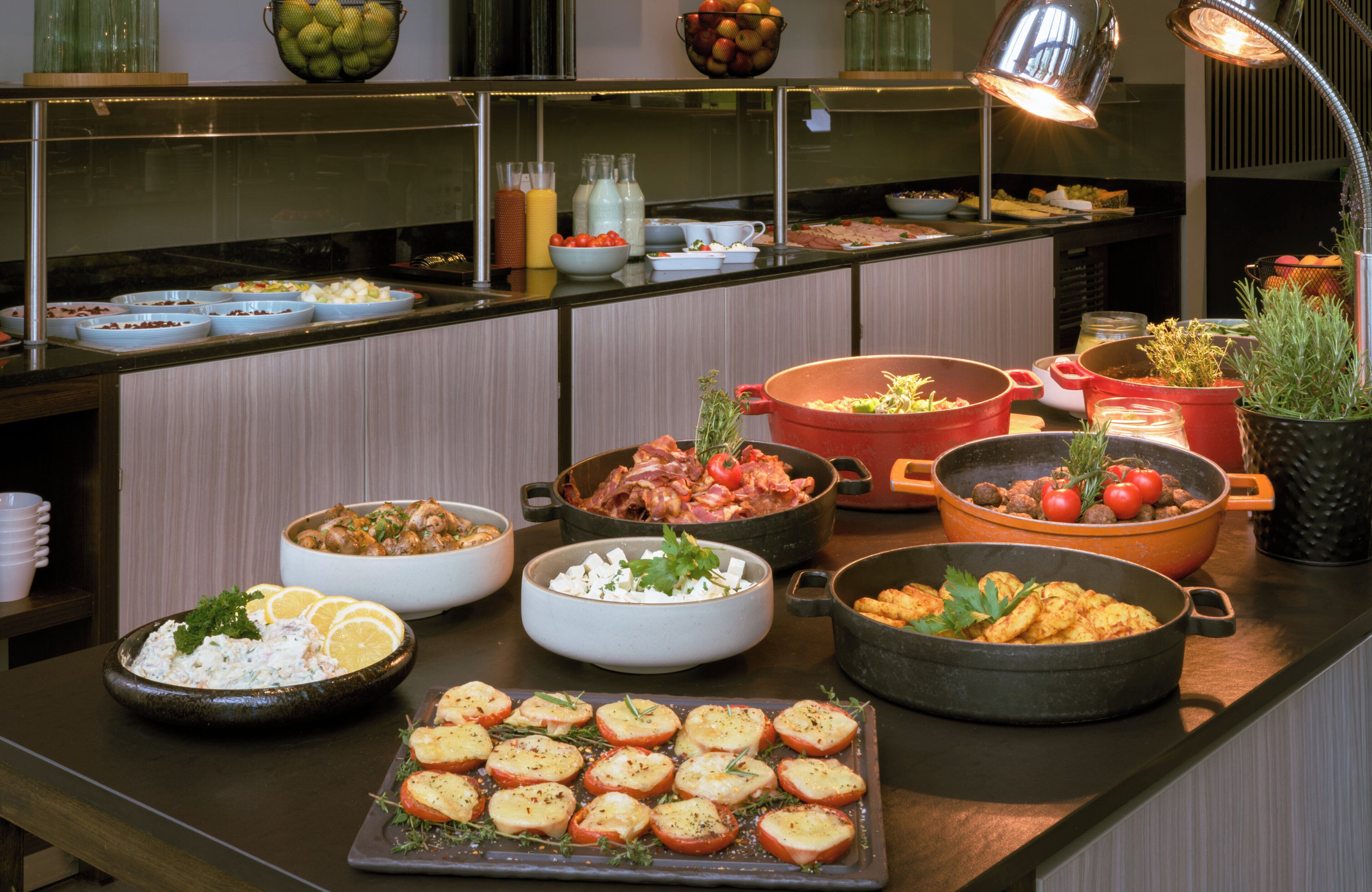 A buffet with various dishes, including salads, meats, and vegetables.