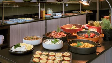 Un bufé con diversos platos, entre ellos ensaladas, carnes y verduras.