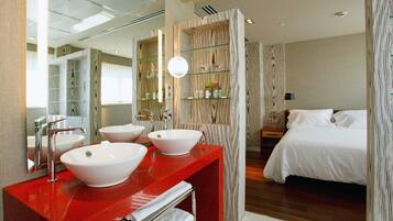 Une salle de bain moderne avec un meuble-lavabo rouge, deux vasques blanches, un grand miroir et un panneau mural en bois.