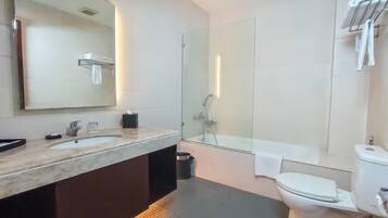 A modern bathroom with a large mirror, a sink, a toilet, and a shower.