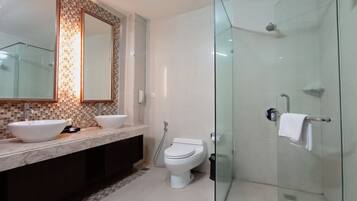 A modern bathroom with a glass shower enclosure, a double sink vanity, and a toilet.