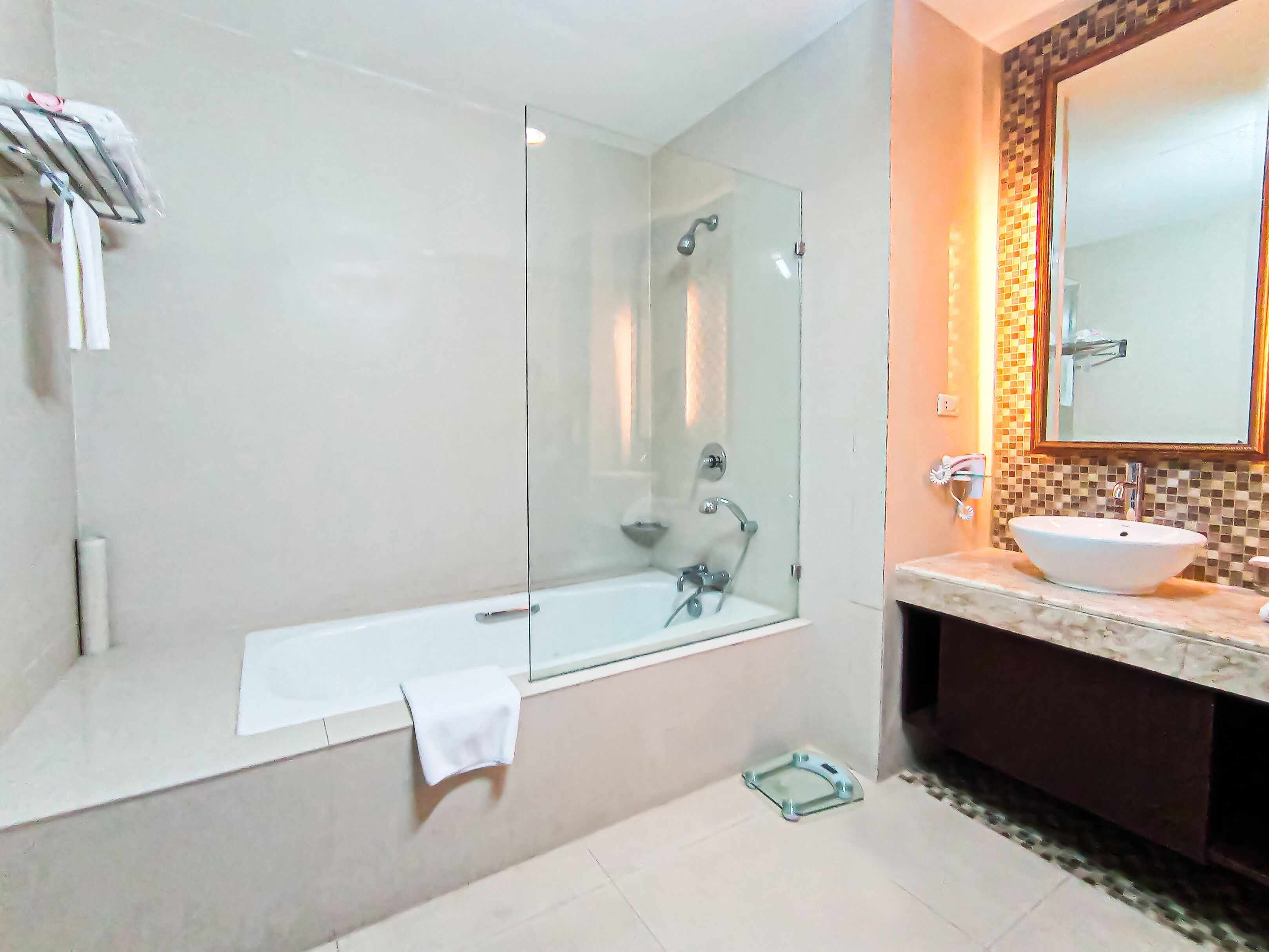 Un bagno moderno con doccia vetrata, una vasca da bagno bianca e un lavandino con specchio sopra.