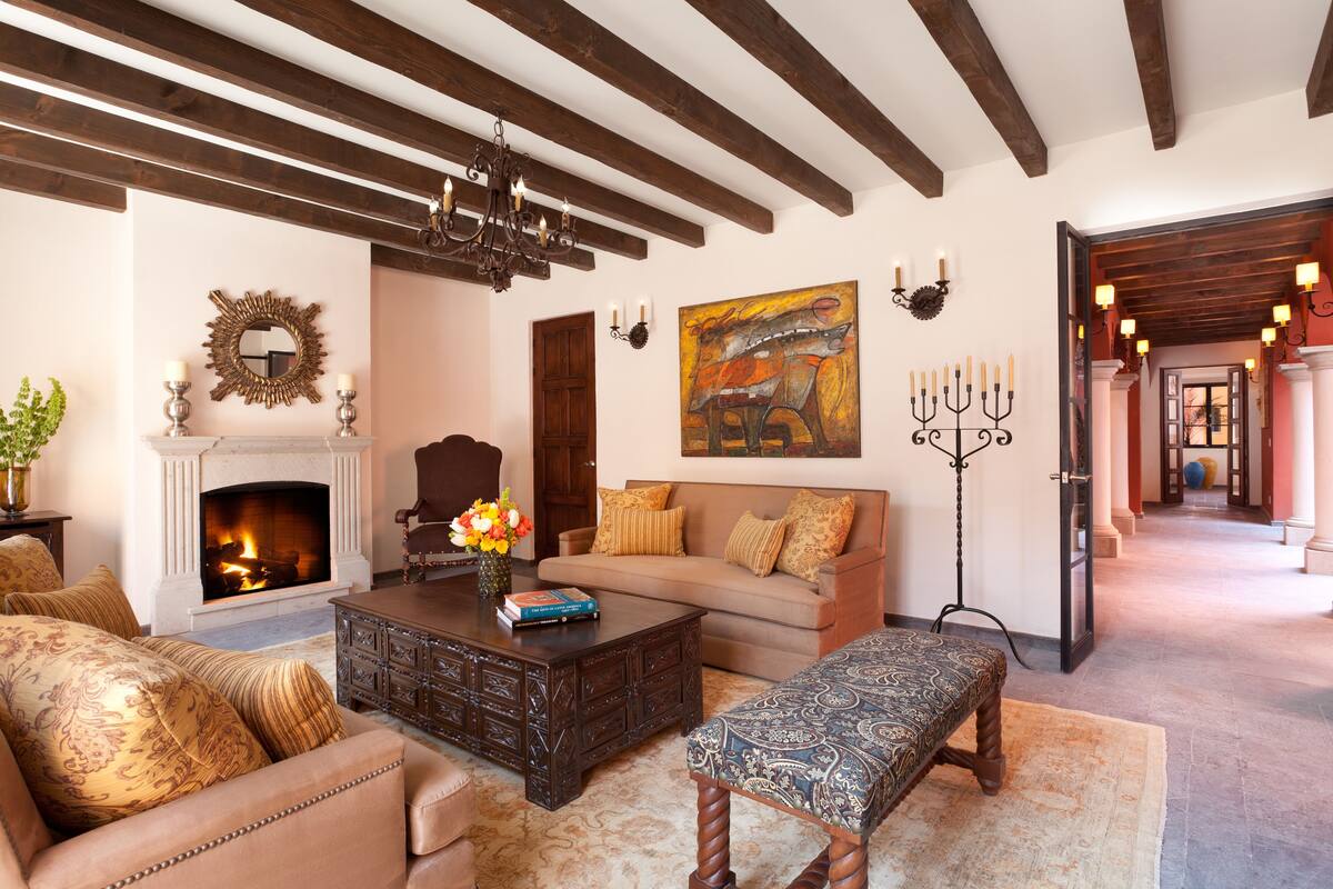 A living room with a fireplace, sofa, coffee table, and bench.