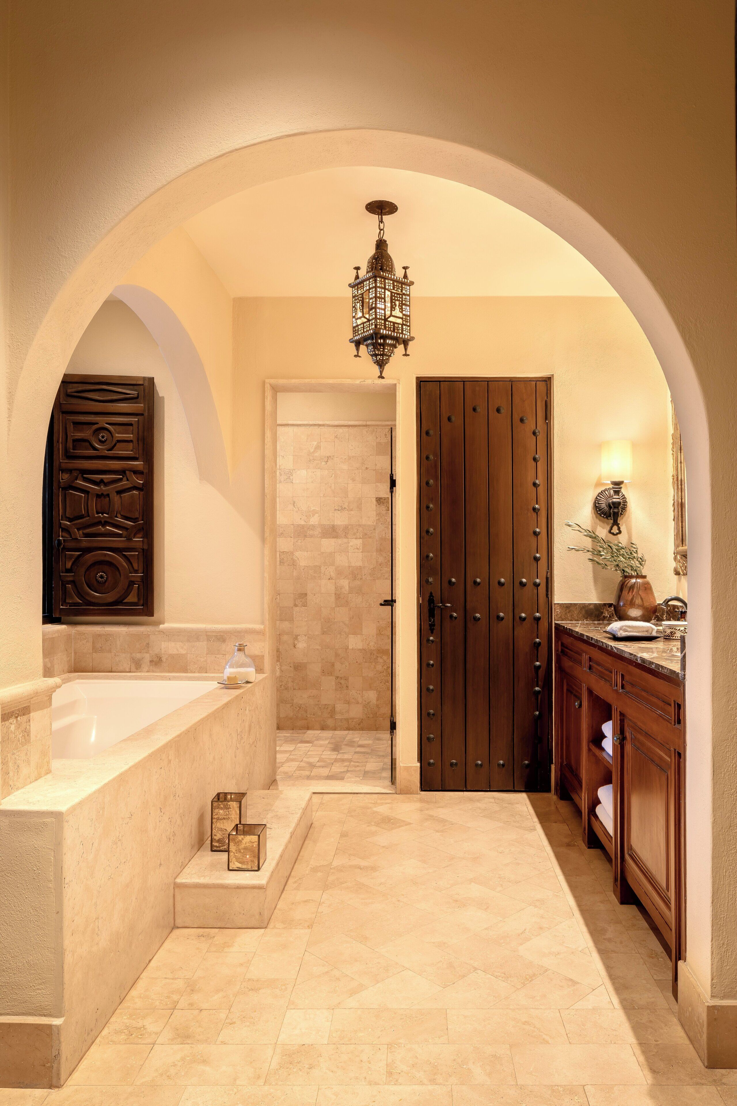 A bathroom with a freestanding bathtub, a wooden door, and a vanity with a mirror.