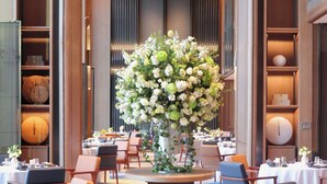 A hotel lobby with a central floral arrangement, multiple dining tables, and chairs. - Sheraton Guangzhou Hotel (Guangzhou)