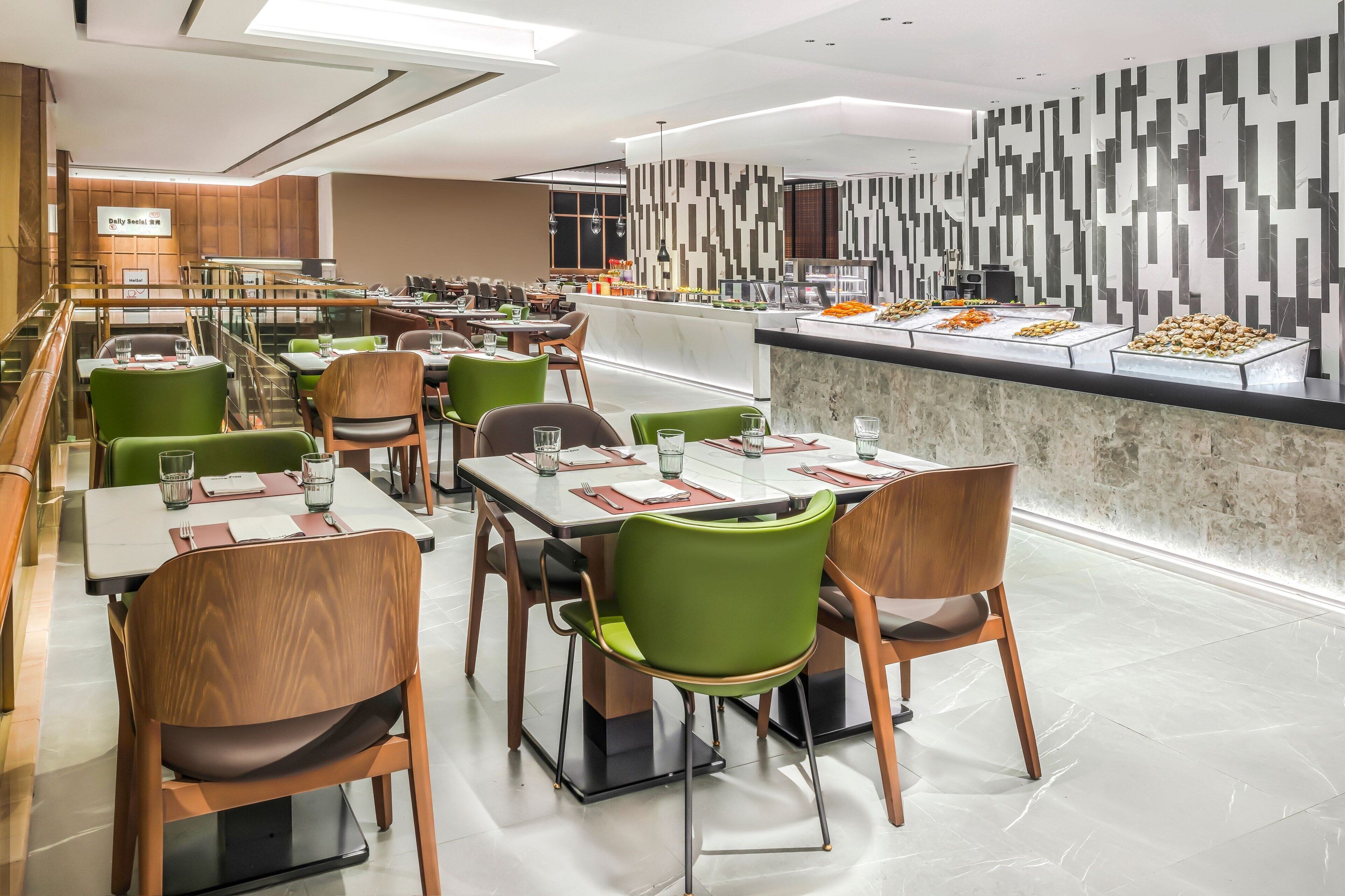 Un restaurante moderno con varias mesas y sillas, una zona de bufé y un diseño de pared contemporáneo.