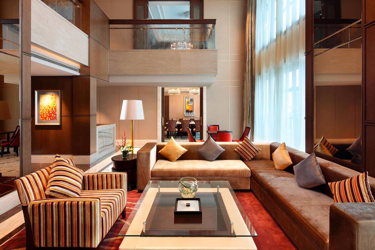 A spacious living area with a sofa set, a coffee table, and a glass-top table.