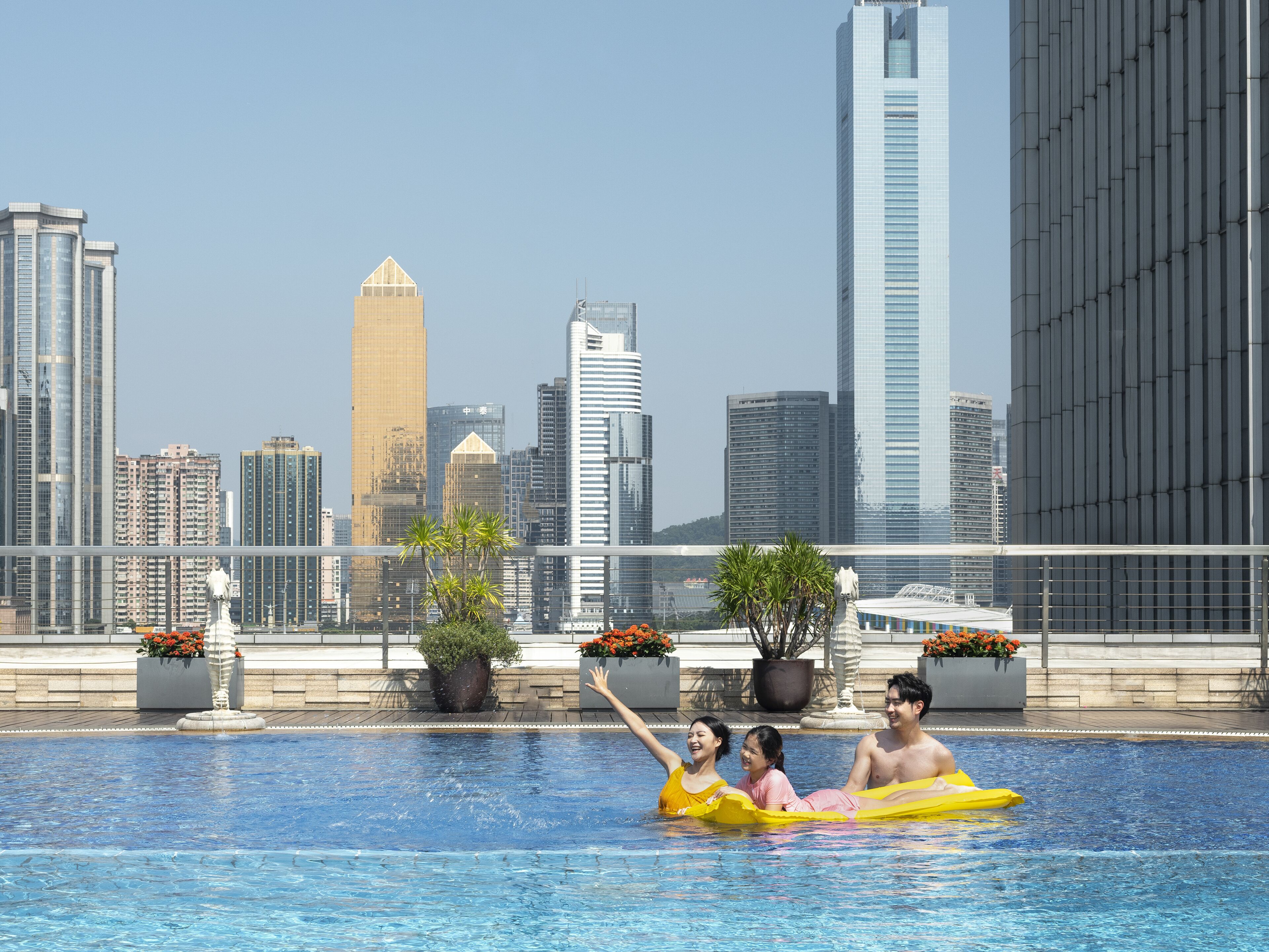 Una piscina al aire libre, sombrillas, sillones reclinables de piscina