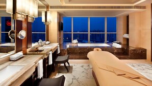 A luxurious bathroom with a large bathtub, a separate shower area, and a vanity with a mirror and multiple sinks. - Sheraton Guangzhou Hotel (Guangzhou)