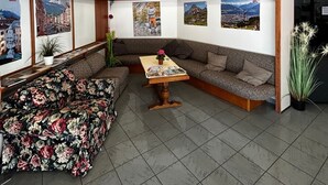 A modern interior with a sofa, a table, and framed pictures on the walls. - Hotel Karwendel (Innsbruck)