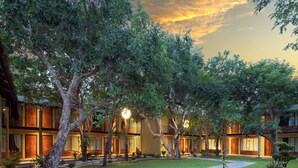 A hotel with multiple floors, outdoor lighting, and a well-maintained lawn. - U Inchantree Kanchanaburi (Kanchanaburi)