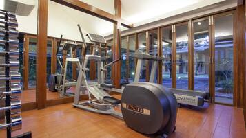 A gym with cardio machines, a weight bench, and a treadmill.