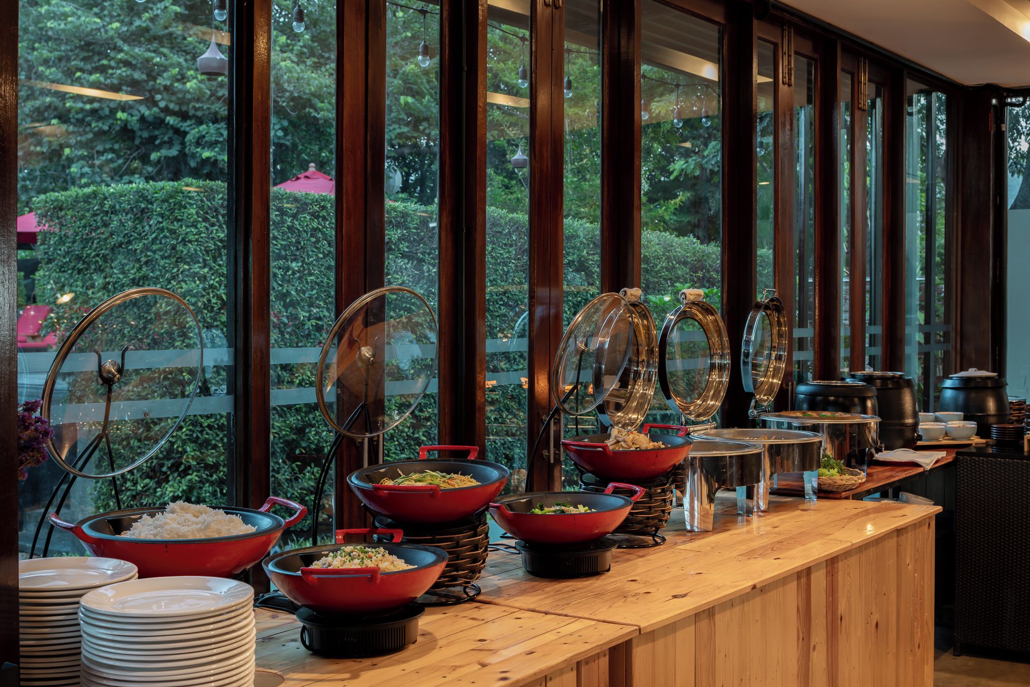 A buffet setup with various food containers and serving utensils.