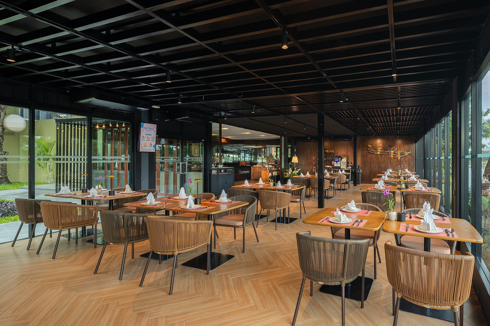 A restaurant with multiple tables and chairs, a wooden floor, and a modern ceiling design.