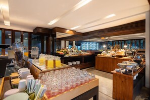 A buffet area with various food items and drink dispensers. - U Inchantree Kanchanaburi (Kanchanaburi)