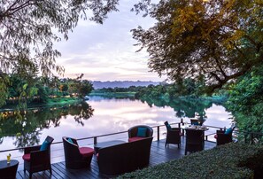 A serene riverside deck with outdoor seating and a view of the surrounding landscape. - U Inchantree Kanchanaburi (Kanchanaburi)