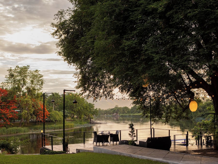 A riverside patio with outdoor seating and a view of the river.
