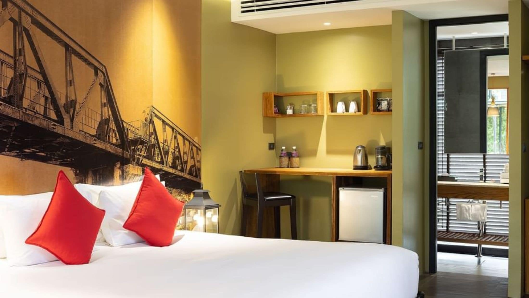 Una habitación de hotel con una cama, un escritorio y una kitchenette.