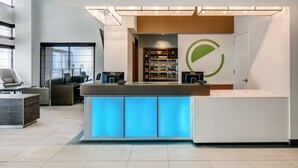 A modern reception area with a desk, seating, and a visible Dell store in the background. - Element by Marriott Omaha Midtown Crossing (Omaha)