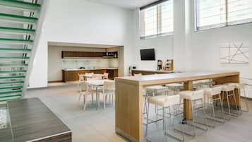 A modern kitchen with a central island, bar stools, and a dining area with chairs.