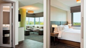 A hotel room with a bed, a desk with a lamp, a sofa, and a view of the outdoors. - Element by Marriott Omaha Midtown Crossing (Omaha)