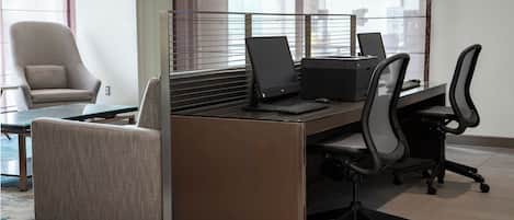 Un espace de bureau moderne comprenant un bureau, deux chaises et un canapé.