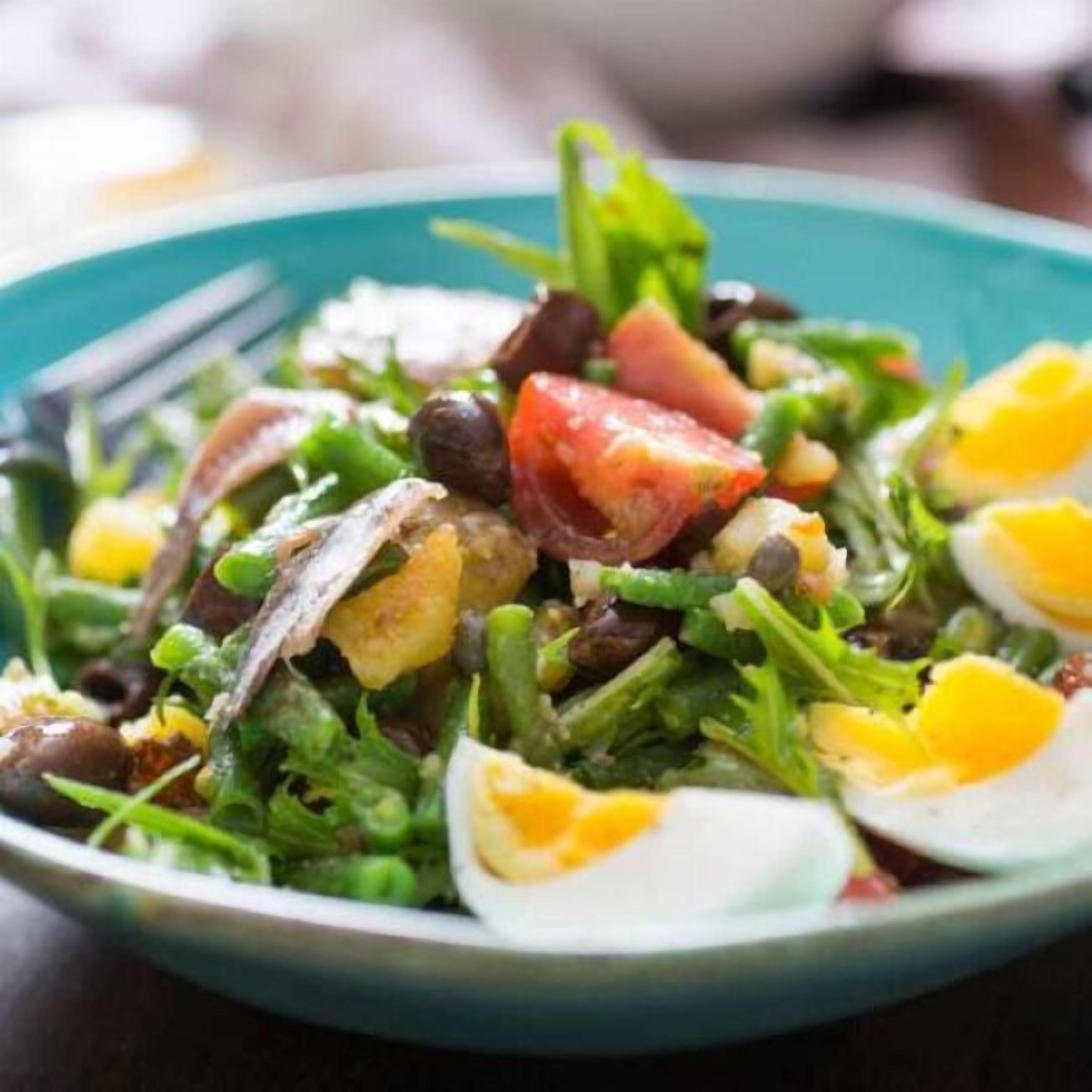 Ensalada con verduras, tomates, huevos y frijoles en un plato.