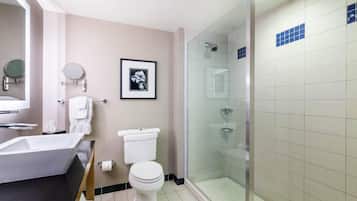 A modern bathroom with a bathtub, toilet, and glass-enclosed shower.