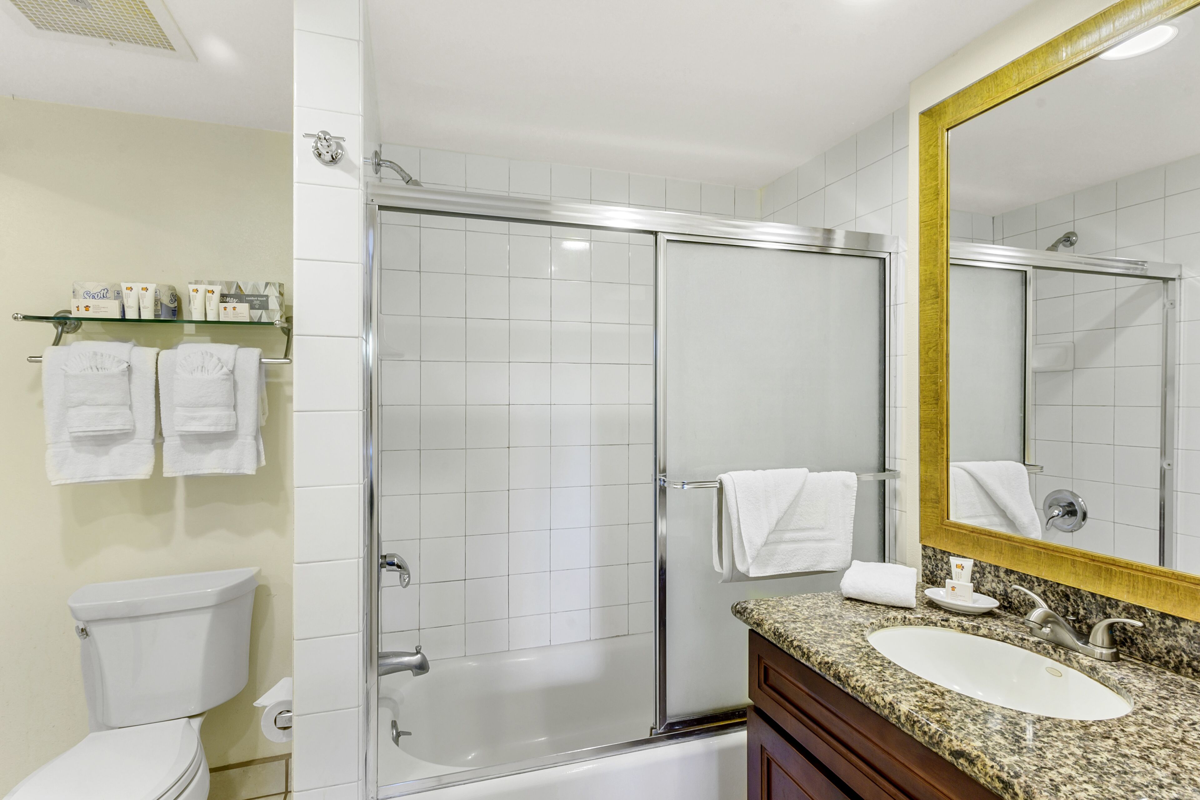 Une salle de bain moderne avec une douche à parois de verre, un lavabo blanc et un grand miroir.