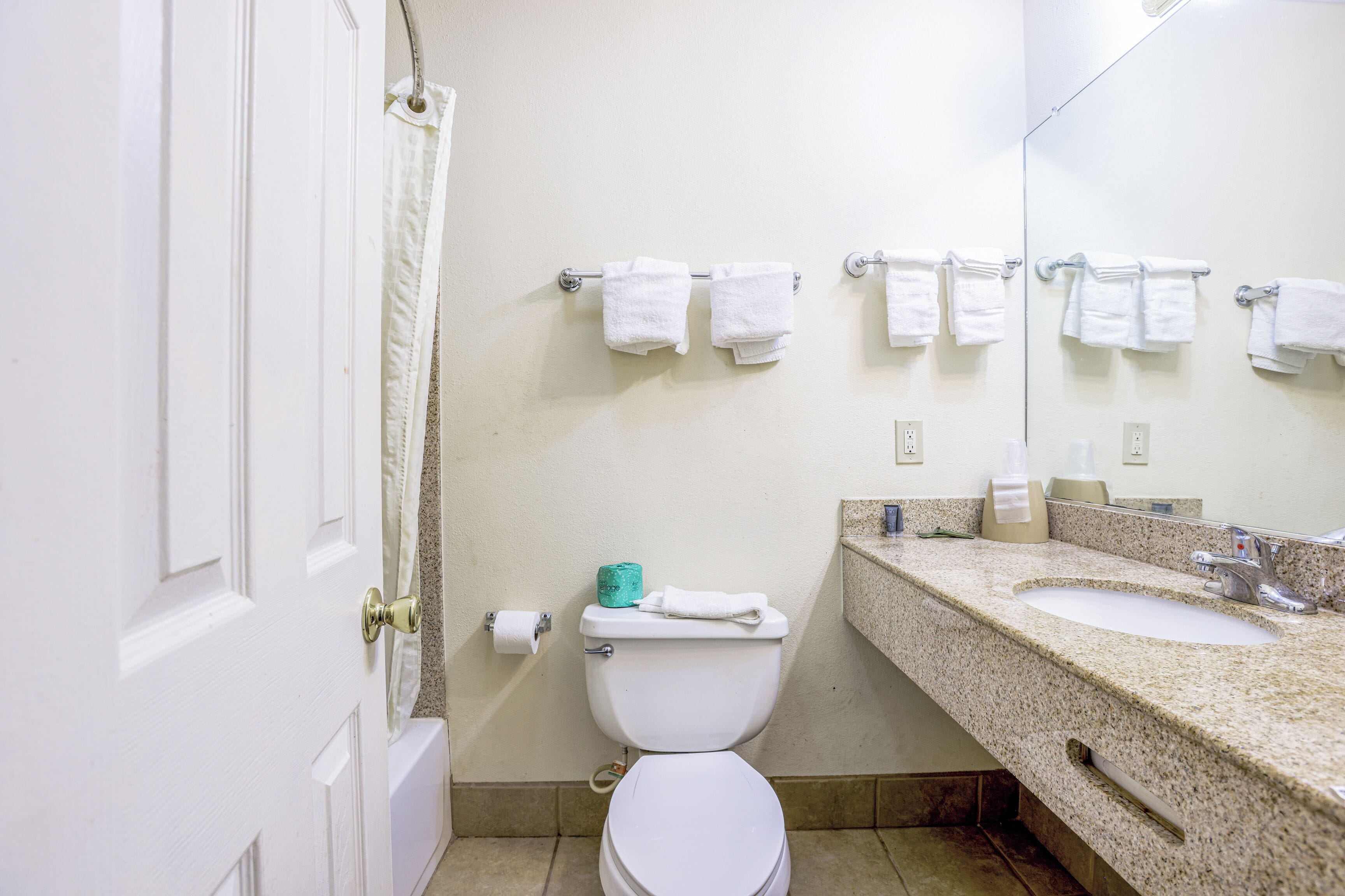A bathroom with a toilet, sink, and towel rack.