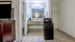 A compact kitchen with a microwave, sink, and a cabinet. - Whispering Pines by Hotel O Whitestone VA (White Stone)