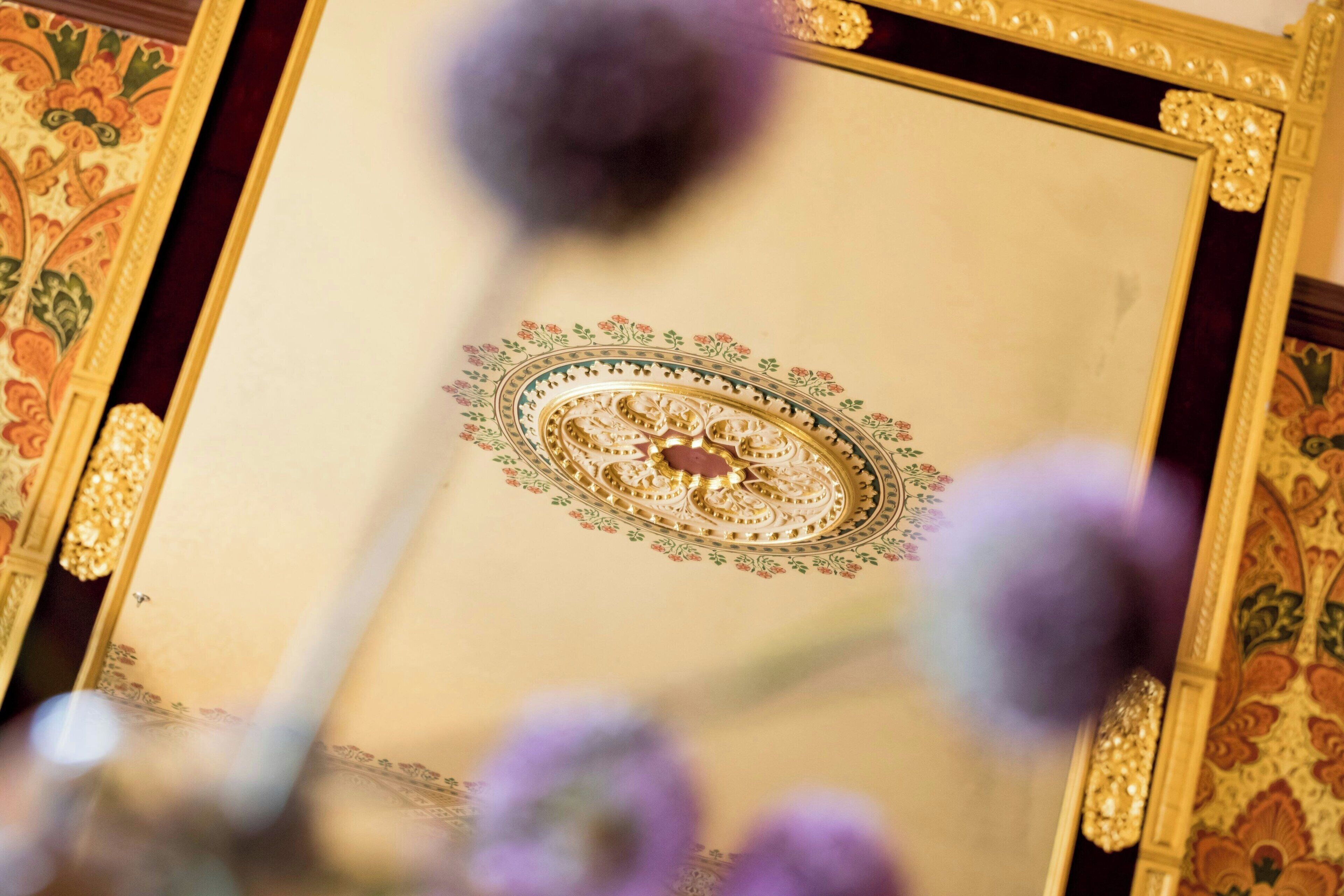 A framed artwork with intricate designs and a central circular motif.